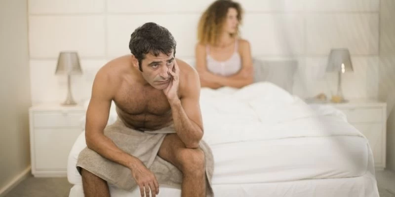 Quý ông mệt mỏi ngồi trên giường vì chuyện “yêu” không như mong muốn